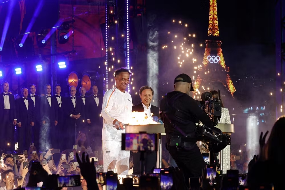 Yannick Noah portant la flamme olympique · Paris 2024